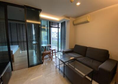 Modern living room with glass partition, sofa, coffee table, and air conditioner