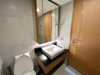 Modern bathroom with sink, mirror, and wooden cabinetry