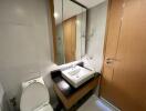 Modern bathroom with sink, mirror, and wooden cabinetry