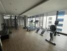 Modern gym with exercise equipment and large windows