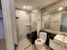 Modern bathroom with tiled walls, glass shower, and white fixtures