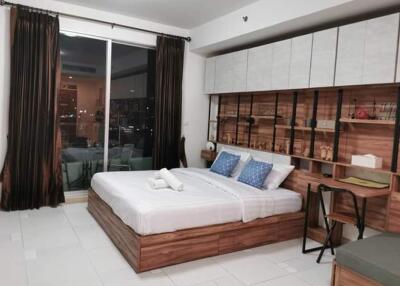 Modern bedroom with large window, double bed, and wooden decor