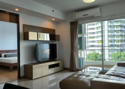 Modern living room with large window and view of adjacent buildings