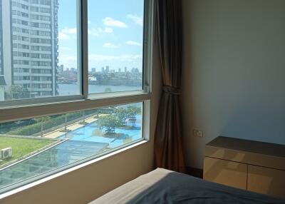 Bedroom with large window view of city and swimming pool