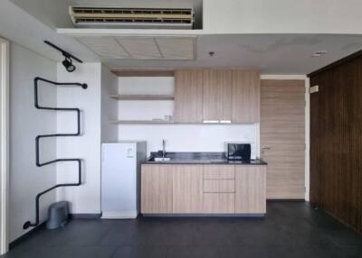 Modern kitchen with wooden cabinets, microwave, and refrigerator