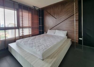 Modern bedroom with wooden accent wall and large windows