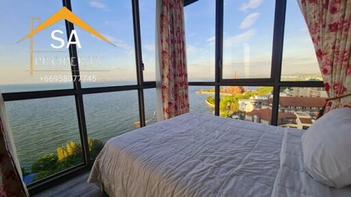 Bedroom with large windows and scenic water view