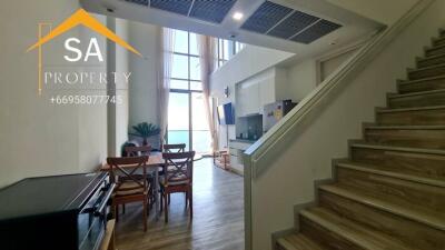 Main living area with dining set, kitchen, and staircase