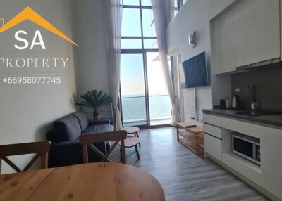 Modern living room and kitchen area with ocean view