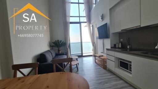 Modern living room and kitchen area with ocean view