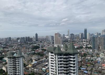 Cityscape view with high-rise buildings and a cloudy sky.