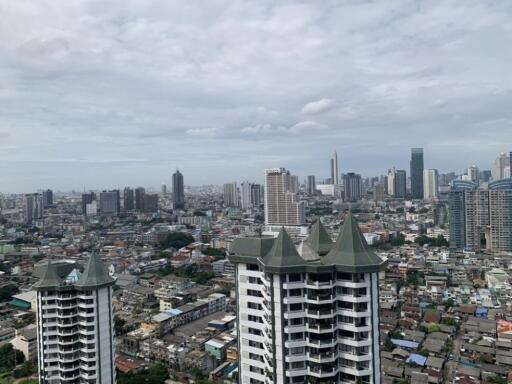 Cityscape view with high-rise buildings and a cloudy sky.