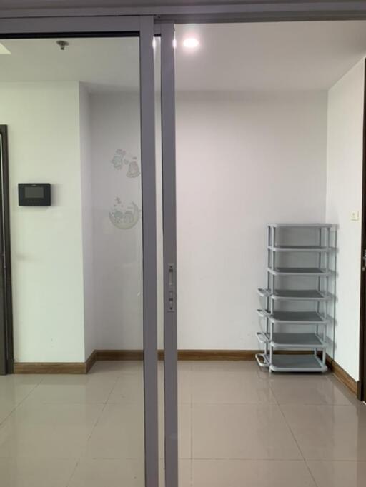 Empty main living area with a sliding glass door and a shelf