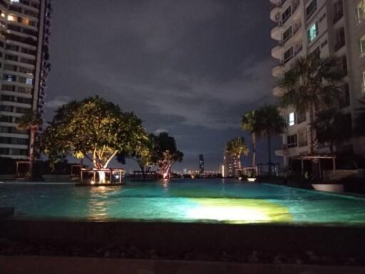 Swimming pool area at night with city view