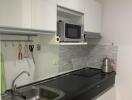 Modern kitchen with white cabinetry and black countertop