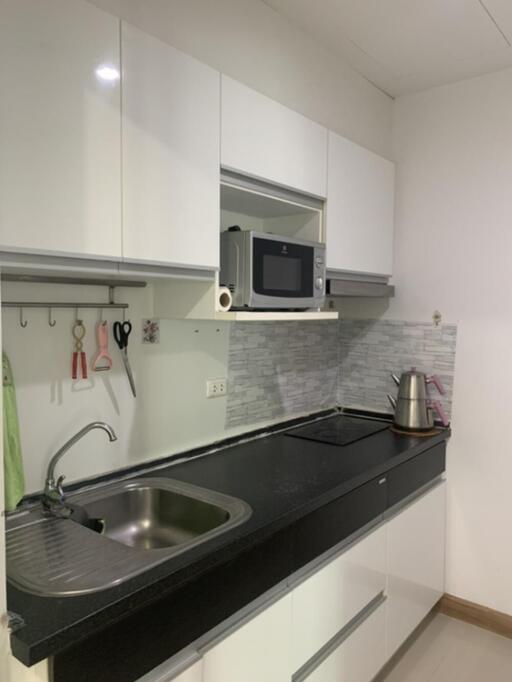 Modern kitchen with white cabinetry and black countertop