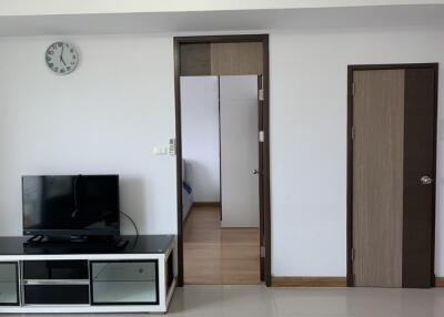 Living room with TV and visible doorway to bedroom