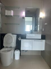 Modern bathroom with toilet, sink, and mirror