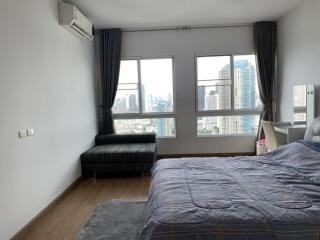 Spacious bedroom with a large window and city view