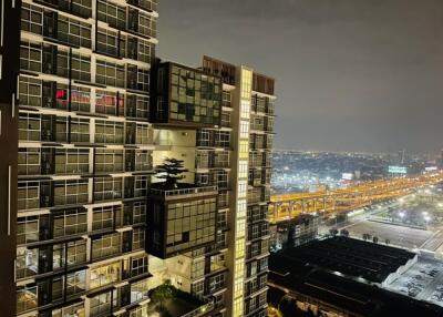 Night view of a modern high-rise apartment building with cityscape in the background