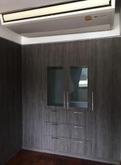 Bedroom with large wooden wardrobe and air conditioning unit