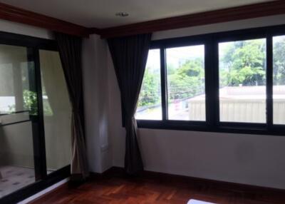 Spacious bedroom with large windows and balcony access