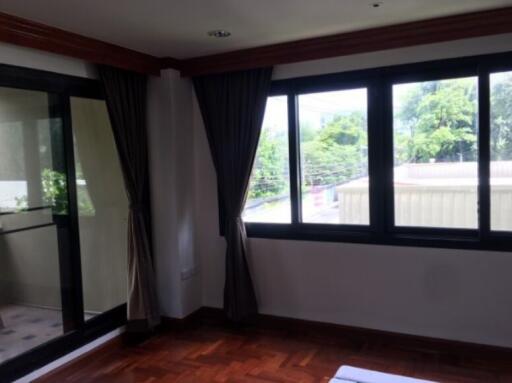 Spacious bedroom with large windows and balcony access