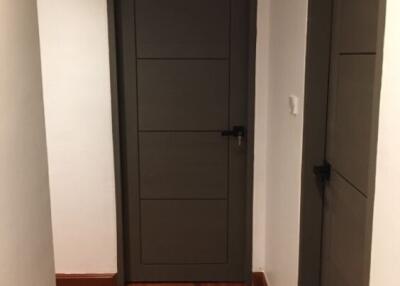 Hallway with wooden flooring and dark doors