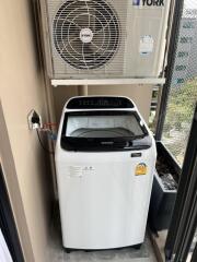 Dedicated laundry area with a washing machine and air conditioning unit