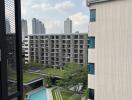 View from the building balcony overlooking the pool and cityscape