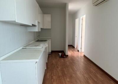 Modern kitchen with white cabinets and wooden floor