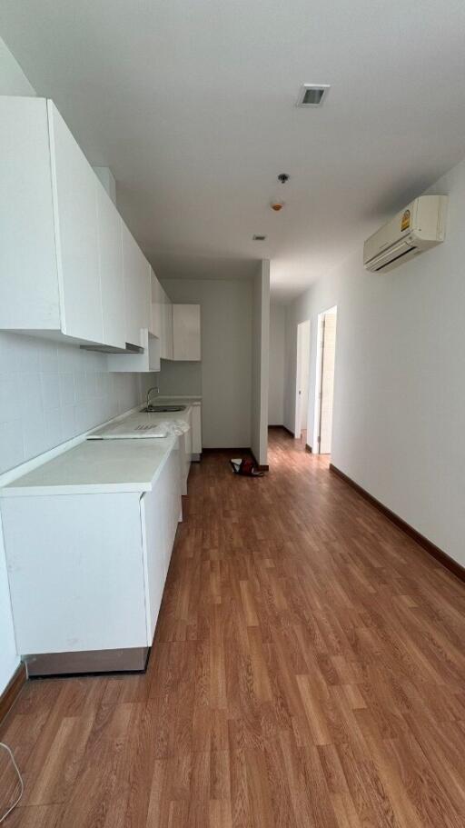 Modern kitchen with white cabinets and wooden floor