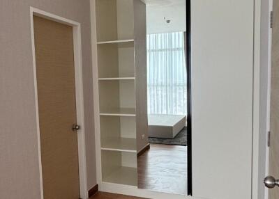 Empty bedroom with built-in shelving and large window