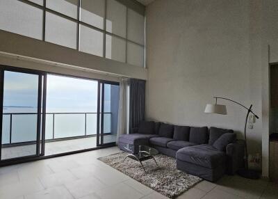 Living room with large floor-to-ceiling windows and ocean view