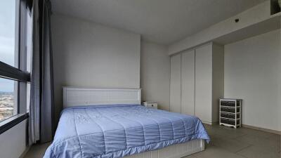 Modern bedroom with large window and blue bedding