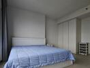 Modern bedroom with large window and blue bedding