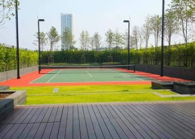 Modern outdoor tennis court surrounded by greenery