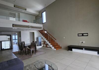 Spacious living room with high ceiling and loft area