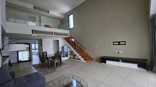 Spacious living room with high ceiling and loft area