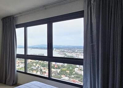 Bedroom with large window and city view