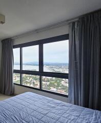 Bedroom with large window and city view