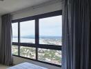 Bedroom with large window and city view