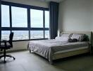 Modern bedroom with large windows and city view