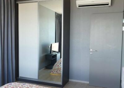 Bedroom with large mirrored wardrobe and air conditioning unit