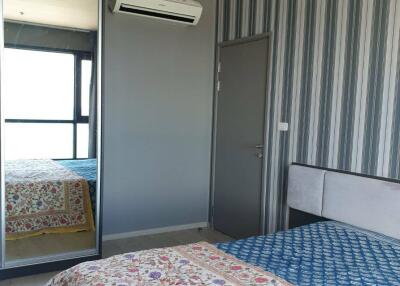 Bedroom with patterned bedspread, mirrored wardrobe, and air conditioning