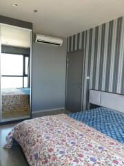 Bedroom with patterned bedspread, mirrored wardrobe, and air conditioning