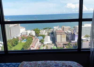 Bedroom with a view of the ocean and city buildings