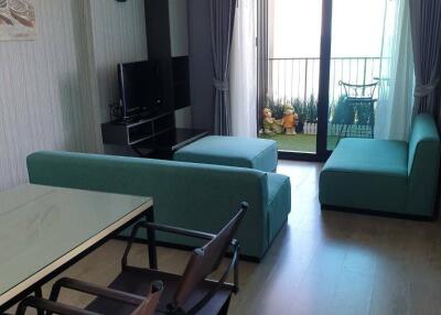 Living room with teal furniture and view of a balcony