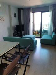 Living room with teal furniture and view of a balcony