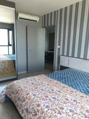 Bedroom with patterned bedding and striped wallpaper